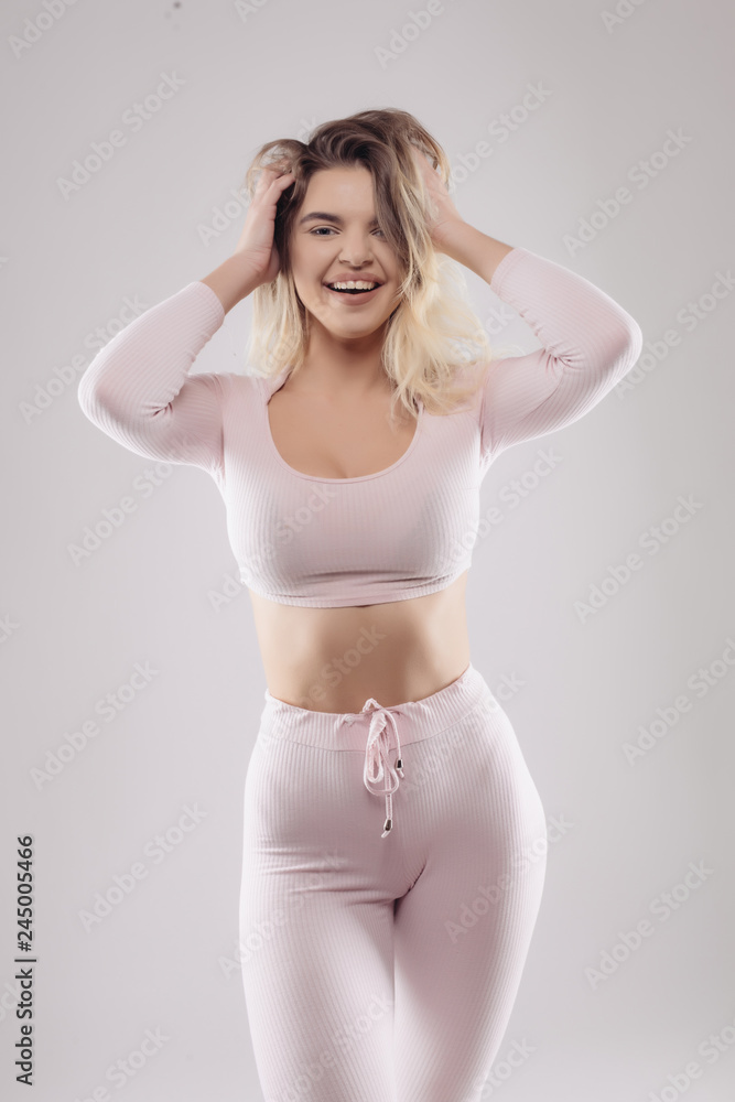 Portrait of sexy young woman ready wearing for workout on grey background Portrait of sexy young woman ready wearing for workout on grey background