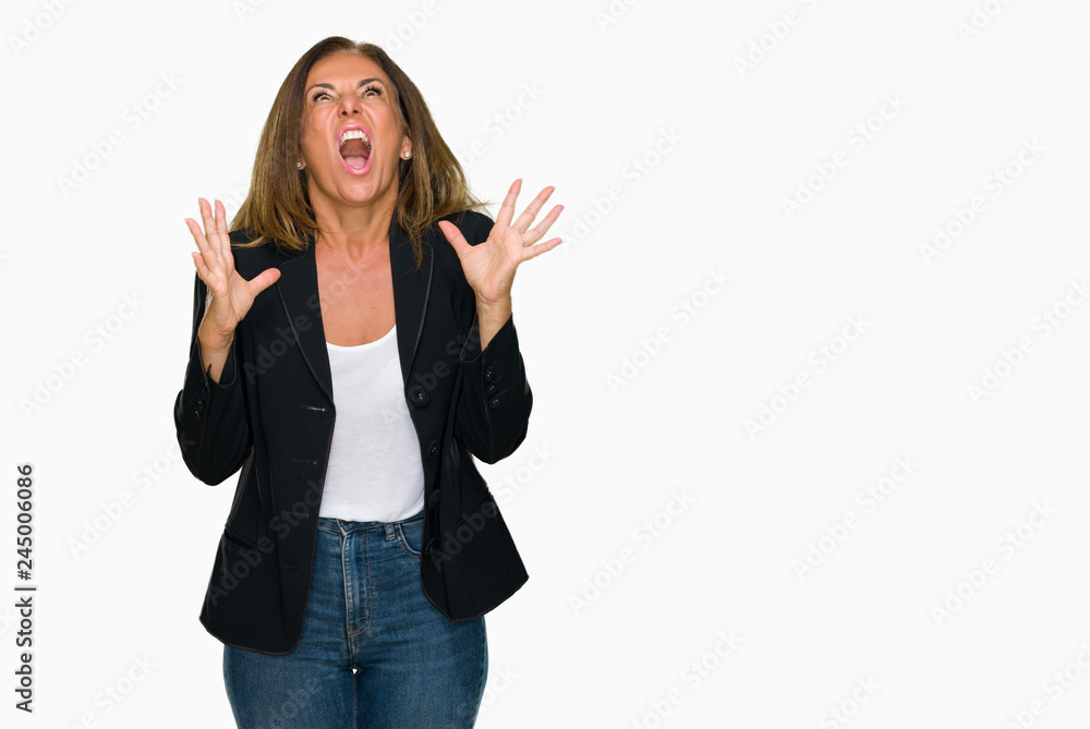 Beautiful middle age business adult woman over isolated background crazy and mad shouting and yelling with aggressive expression and arms raised. Frustration concept. Beautiful middle age business adult woman over isolated background crazy and mad shouting and yelling with aggressive expression and arms raised. Frustration concept.
