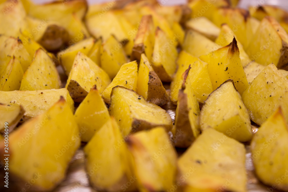 Baked potato wedges with herbs are ready to eat. Homemade potato wedges snack food.