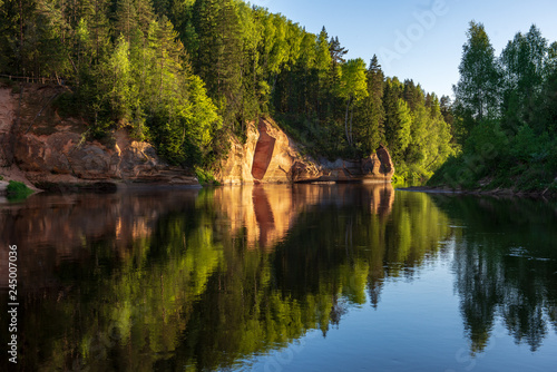 blue sky and clouds reflecting in calm water of river Gauja in latvia in autumn