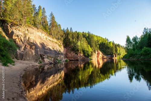 blue sky and clouds reflecting in calm water of river Gauja in latvia in autumn