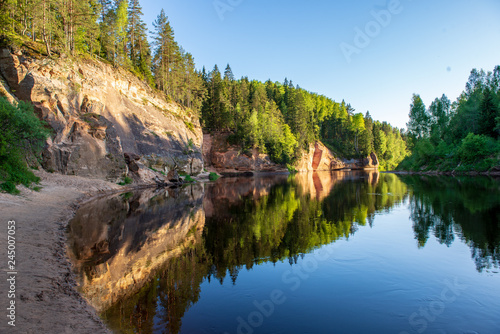 blue sky and clouds reflecting in calm water of river Gauja in latvia in autumn