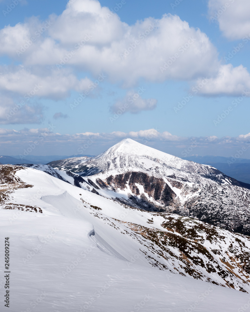Obraz premium View of the stony hills with snow and blue sky. Dramatic spring scene. Landscape photography