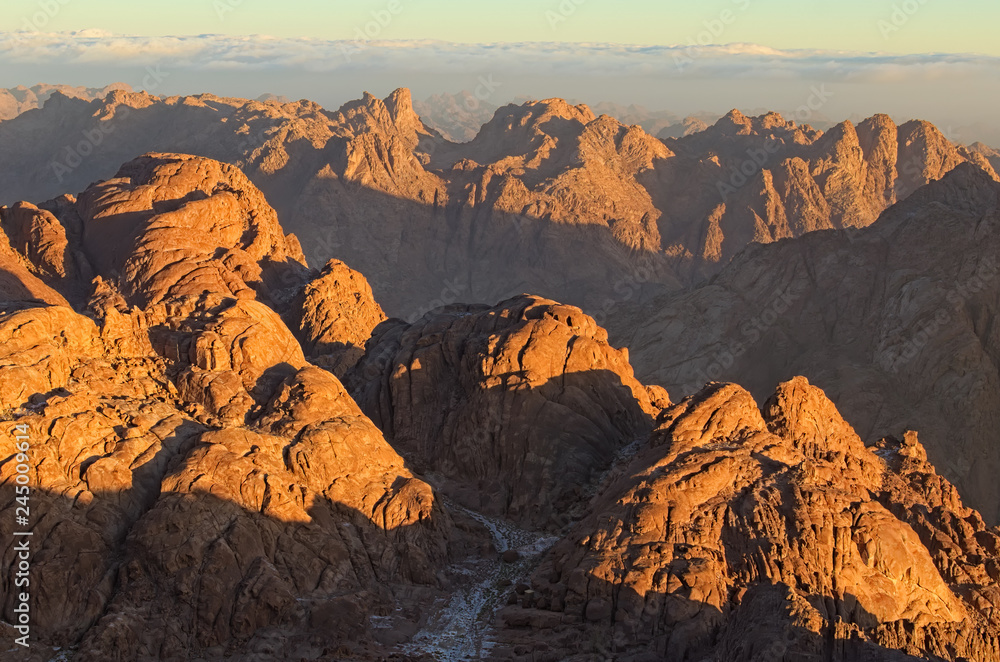 Picturesque sunrise at Sinai Mountain (Mount Horeb, Gabal Musa, Moses Mount). Sinai Peninsula of Egypt. Thick fog in the background. Pilgrimage place and famous touristic destination