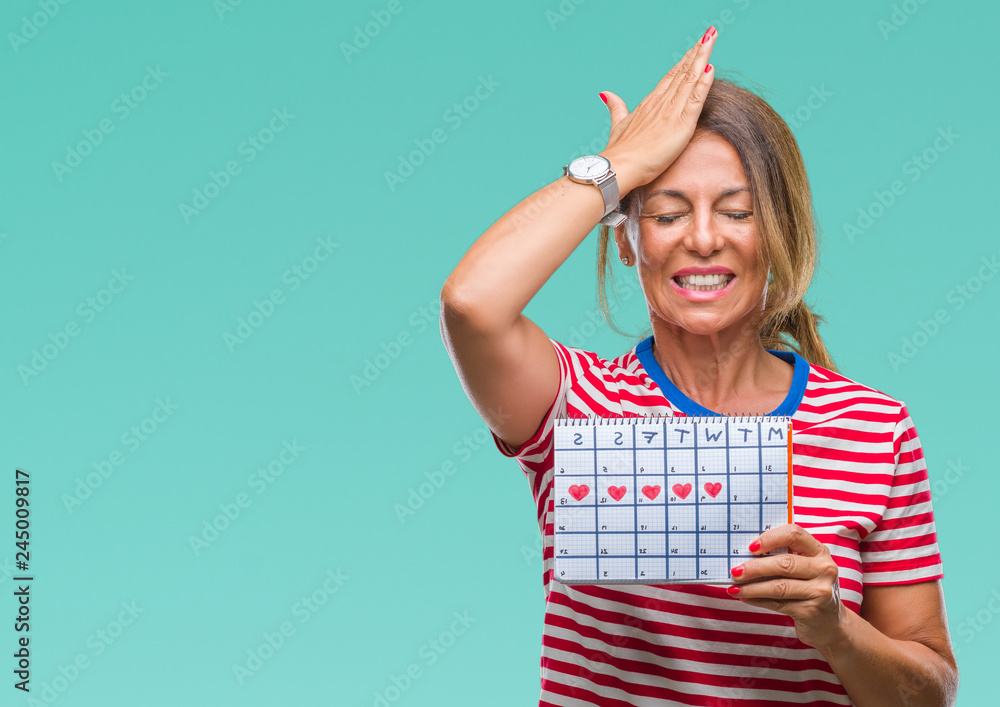 Middle age senior hispanic woman holding menstruation calendar over isolated background stressed with hand on head, shocked with shame and surprise face, angry and frustrated. Fear and upset Middle age senior hispanic woman holding menstruation calendar over isolated background stressed with hand on head, shocked with shame and surprise face, angry and frustrated. Fear and upset