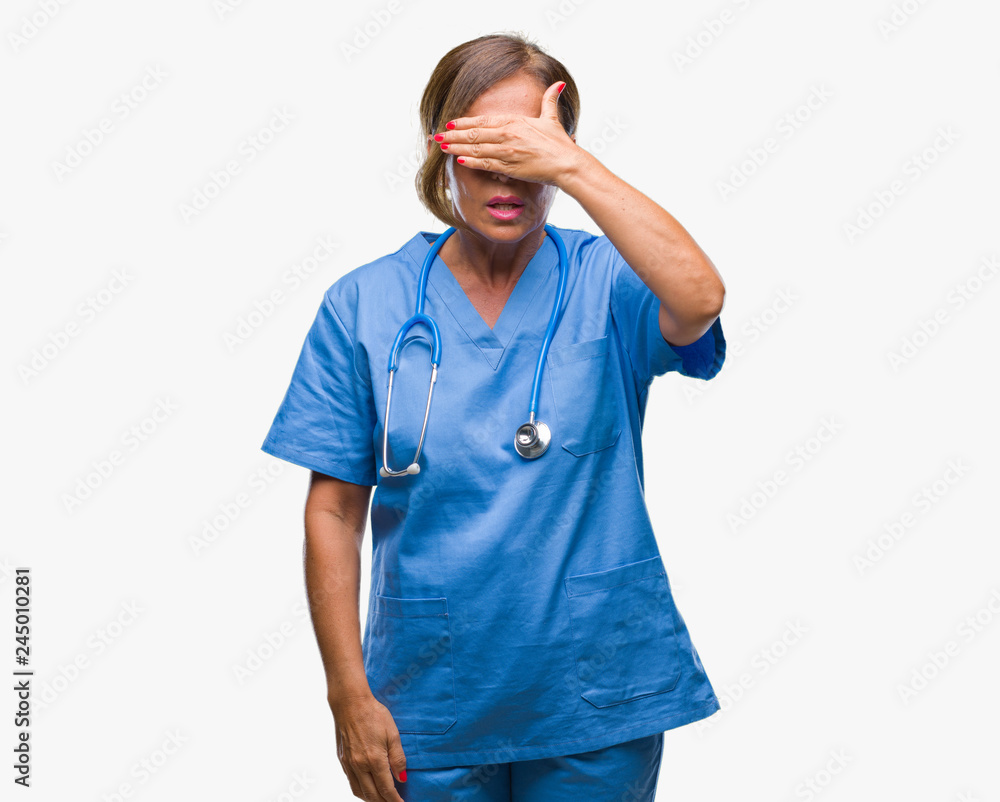 Middle age senior nurse doctor woman over isolated background smiling and laughing with hand on face covering eyes for surprise. Blind concept. Middle age senior nurse doctor woman over isolated background smiling and laughing with hand on face covering eyes for surprise. Blind concept.