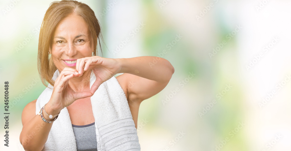 Beautiful middle age woman wearing sport clothes and a towel over isolated background smiling in love showing heart symbol and shape with hands. Romantic concept. Beautiful middle age woman wearing sport clothes and a towel over isolated background smiling in love showing heart symbol and shape with hands. Romantic concept.