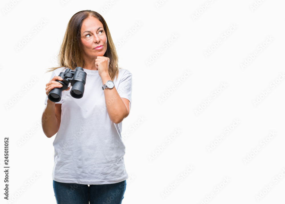 Middle age hispanic woman looking through binoculars over isolated background serious face thinking about question, very confused idea Middle age hispanic woman looking through binoculars over isolated background serious face thinking about question, very confused idea