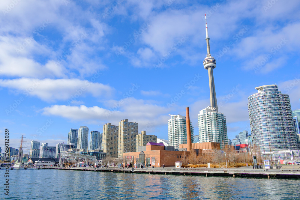 Obraz premium Scenic view of embankment of Ontario lake with skyscrapers of downtown and tower in Toronto. Beautiful winter look of skyline in center of largest megapolis of the province and Canada