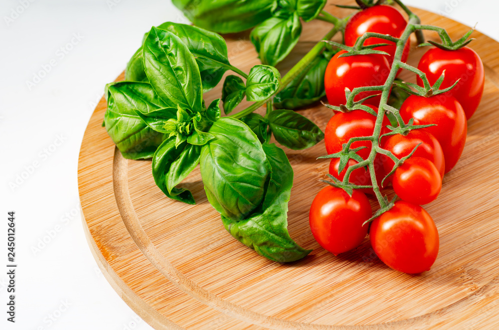 The branch of cherry tomatoes on a wooden background. The branch of cherry tomatoes on a wooden background.