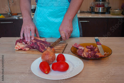 Preparing meal, meat and vegetables. Chef cutting meat on cutting board