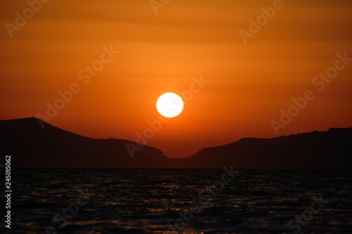 sunset at the sea against the background of mountains close up