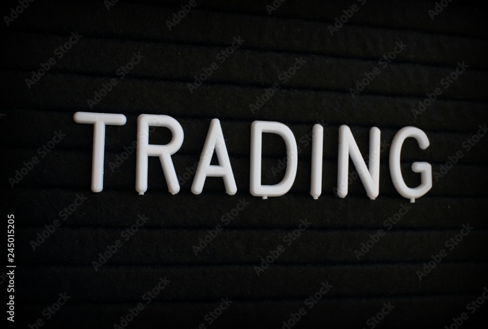 The word Trading in white plastic letters on a black letter board 