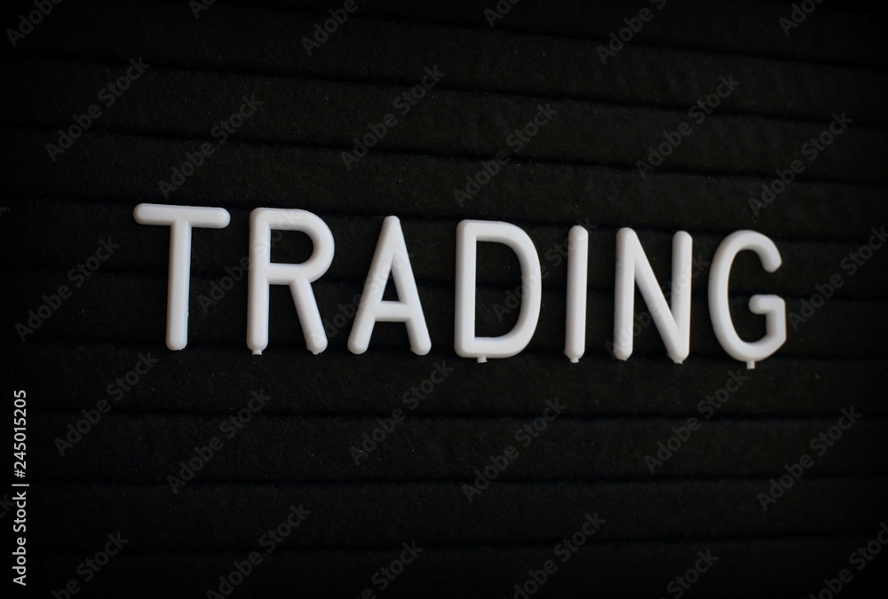 The word Trading in white plastic letters on a black letter board The word Trading in white plastic letters on a black letter board