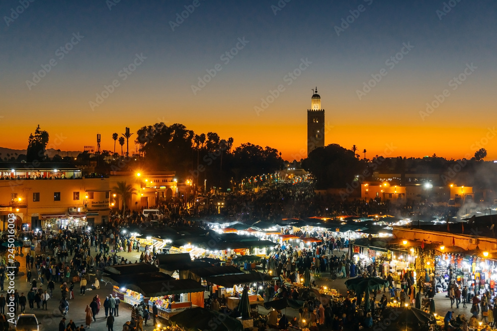 Marrakesh Medina (Marrakech Medina). Jamaa el Fnaa square or Jemaa el-Fna, Djema el-Fna, Djema el-Fnaa market place and Koutoubia mosque minaret
