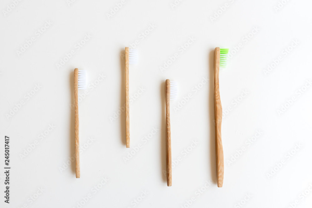 High angle view of four bamboo toothbrushes on white background High angle view of four bamboo toothbrushes on white background