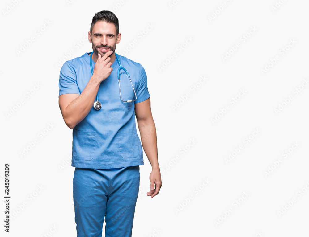 Handsome young doctor surgeon man over isolated background looking confident at the camera with smile with crossed arms and hand raised on chin. Thinking positive. Handsome young doctor surgeon man over isolated background looking confident at the camera with smile with crossed arms and hand raised on chin. Thinking positive.