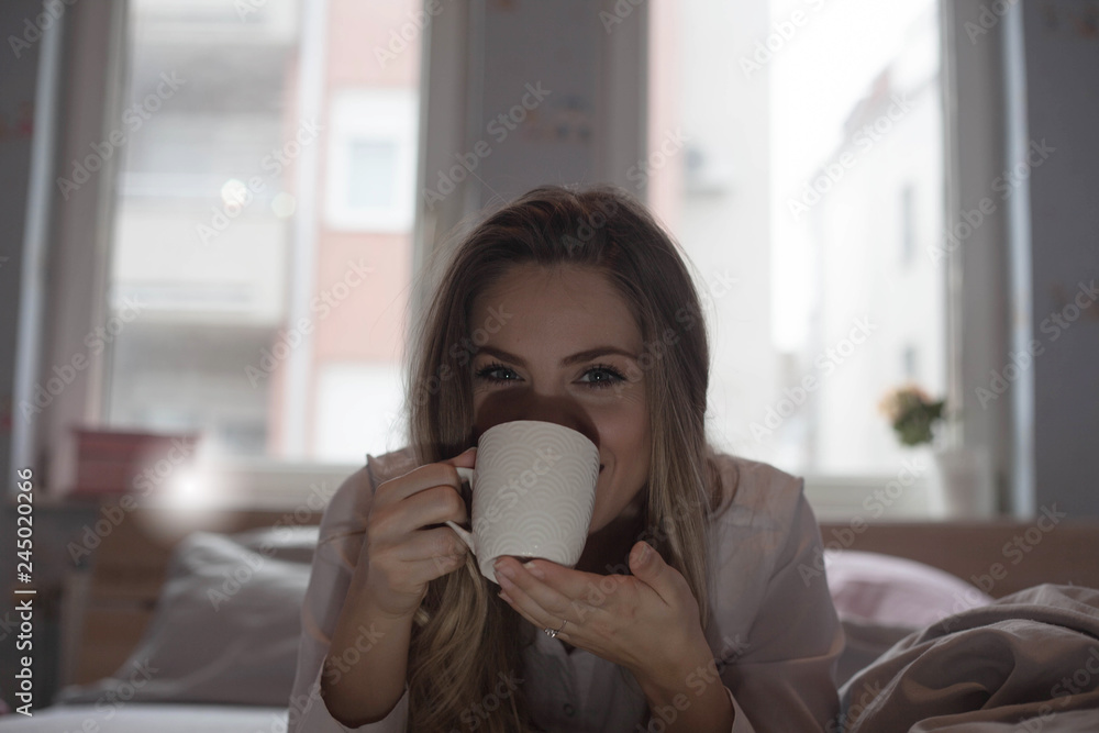 Woman Enjoying a cup of coffee in bed. Woman Enjoying a cup of coffee in bed.