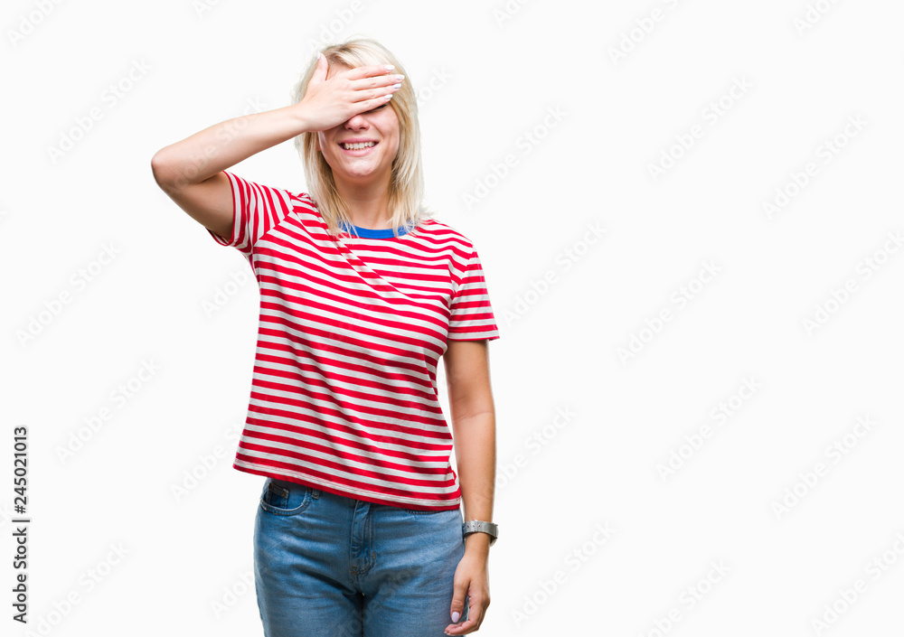 Fototapeta premium Young beautiful blonde woman over isolated background smiling and laughing with hand on face covering eyes for surprise. Blind concept.