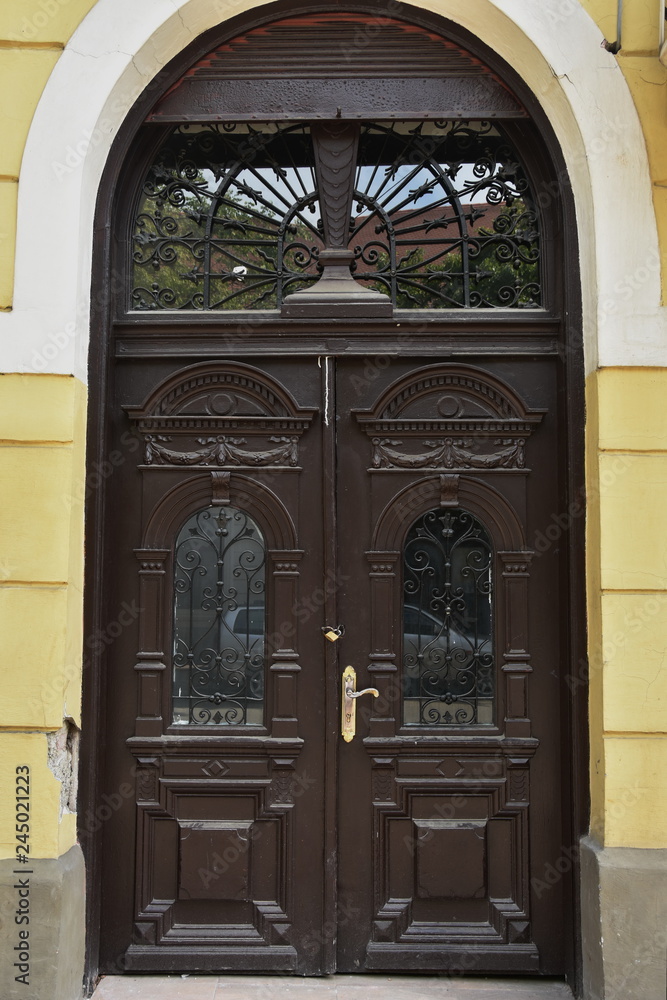 old brown  wooden door with wrought iron  in Bistrita, Romania