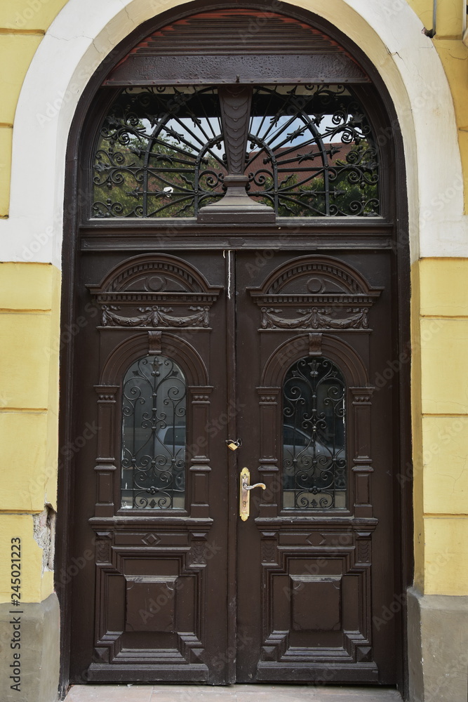 old brown wooden door with wrought iron in Bistrita, Romania old brown wooden door with wrought iron in Bistrita, Romania