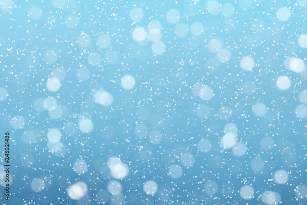 Obraz premium Snow falls on winter blue sky background