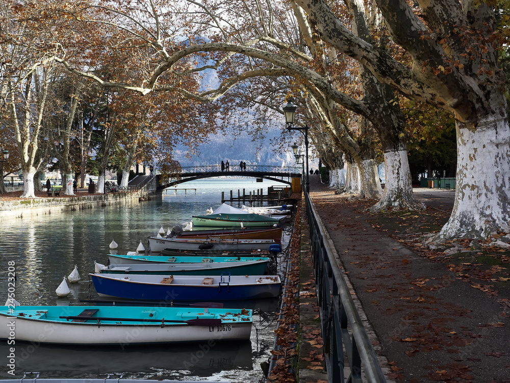 Shot of the beautiful Canal du Vassè which brings to the romantic Pont de Amours in Annecy, France. The canal is full of boats. The shot is taken in autumnal season Shot of the beautiful Canal du Vassè which brings to the romantic Pont de Amours in Annecy, France. The canal is full of boats. The shot is taken in autumnal season