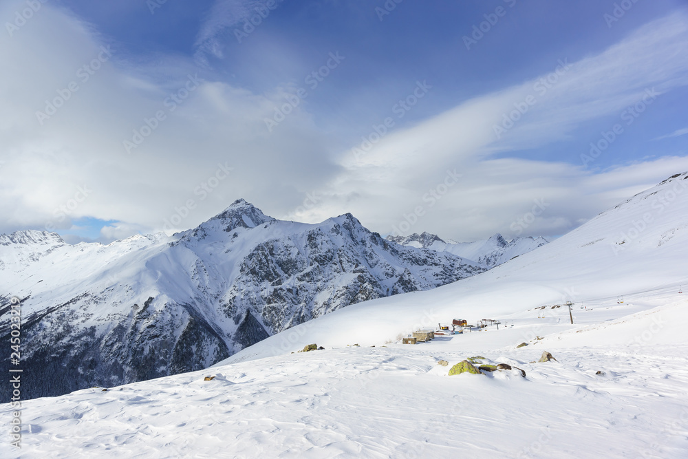 Snow cliffs of the peaks of the main Caucasian ridge near the resort ski village Dombay