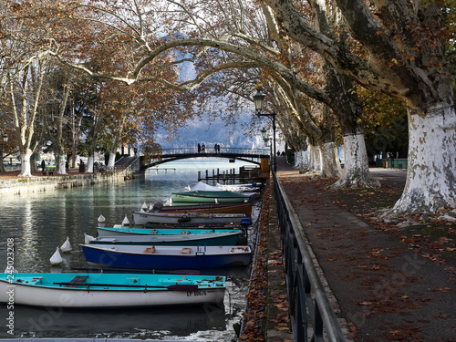 Shot of the beautiful Canal du Vassè which brings to the romantic Pont de Amours in Annecy, France. The canal is full of boats. The shot is taken in autumnal season © gpiazzese