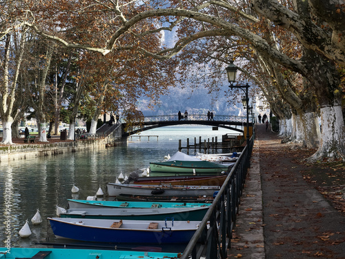 Shot of the beautiful Canal du Vassè which brings to the romantic Pont de Amours in Annecy, France. The canal is full of boats. The shot is taken in autumnal season © gpiazzese