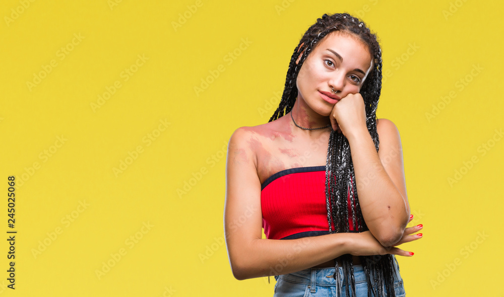 Young braided hair african american with pigmentation blemish birth mark over isolated background with hand on chin thinking about question, pensive expression. Smiling with thoughtful face Young braided hair african american with pigmentation blemish birth mark over isolated background with hand on chin thinking about question, pensive expression. Smiling with thoughtful face