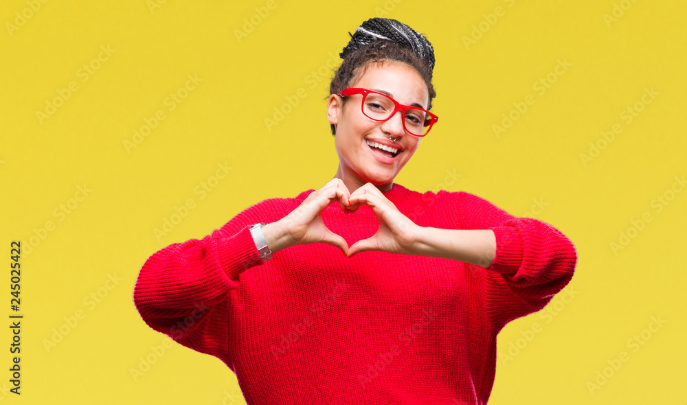 Young braided hair african american girl wearing sweater and glasses over isolated background smiling in love showing heart symbol and shape with hands. Romantic concept. Young braided hair african american girl wearing sweater and glasses over isolated background smiling in love showing heart symbol and shape with hands. Romantic concept.