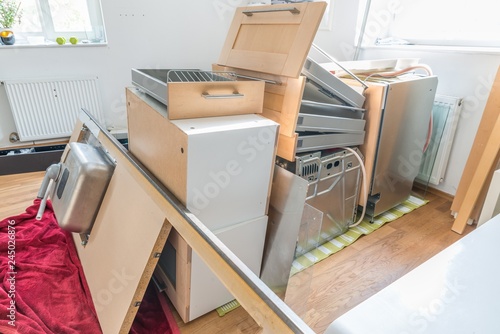 In Einzelteile zerlegte Einbauküche aufgebahrt im Wohnzimmer