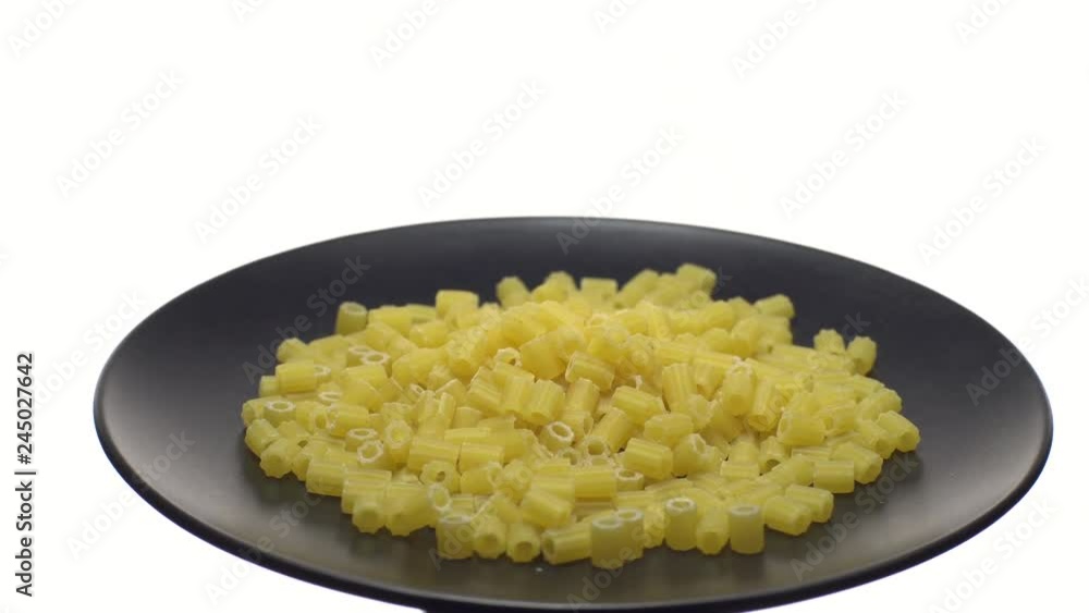 Raw macaroni in rotation. Ditalini lisci. Close up. Raw pasta isolated on white. Italian cuisine concept. Ditalini, Ditalini lisci, piccoli lisci, Raw macaroni in rotation. Ditalini lisci. Close up. Raw pasta isolated on white. Italian cuisine concept. Ditalini, Ditalini lisci, piccoli lisci,