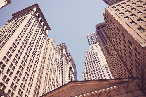 Looking up at Wall Street buildings, color toned picture, New York, USA.