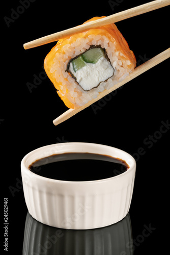 sushi rolls with chopsticks on black background