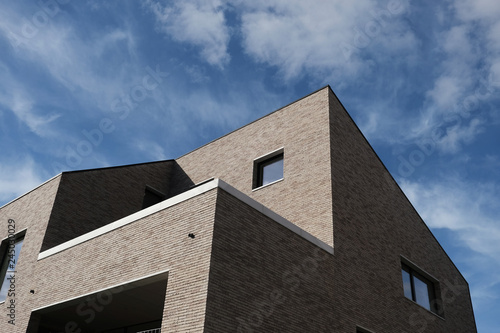 modern brown brick building against blue sky