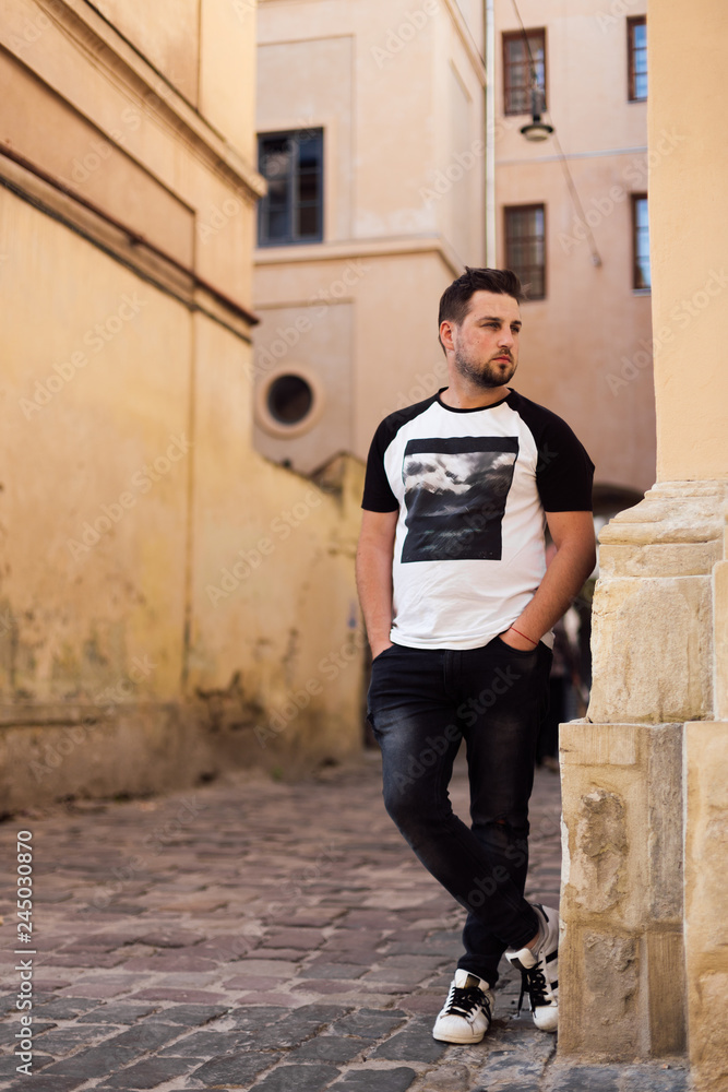Young man in t-shirt walking in old town Young man in t-shirt walking in old town