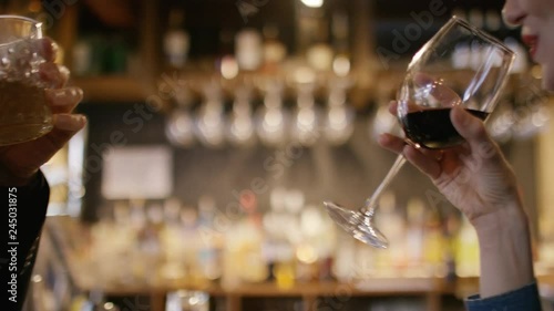 Young couple at the bar toast and drink their drinks photo