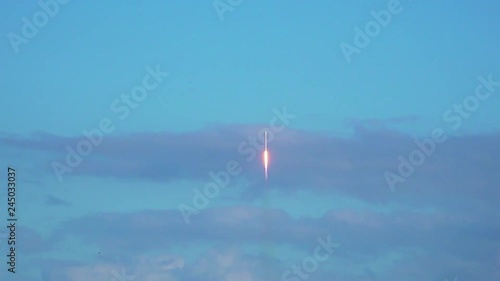 Space rocket lifting-off into space with exhaust flames and smoke. Beautiful clouds and sky. Wide-angle.  120 fps slow motion. photo