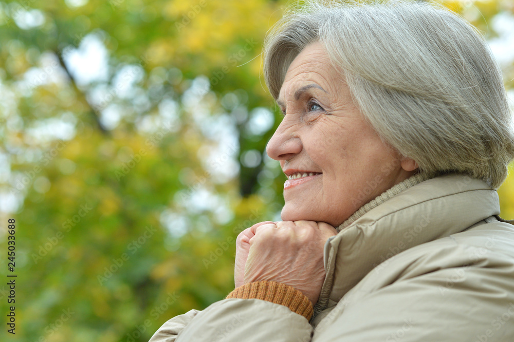 Portrait of happy senior beautiful woman in autumnal park Portrait of happy senior beautiful woman in autumnal park