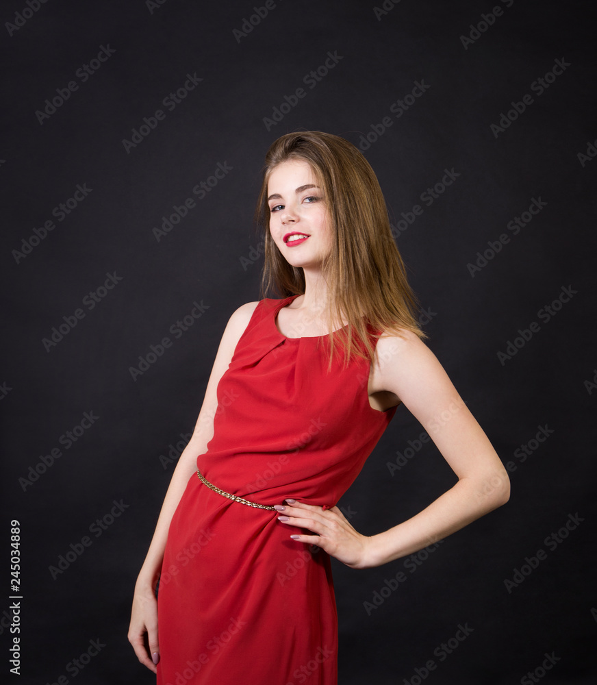 A beautiful girl in a red dress with long hair and a make-up. A beautiful girl in a red dress with long hair and a make-up.