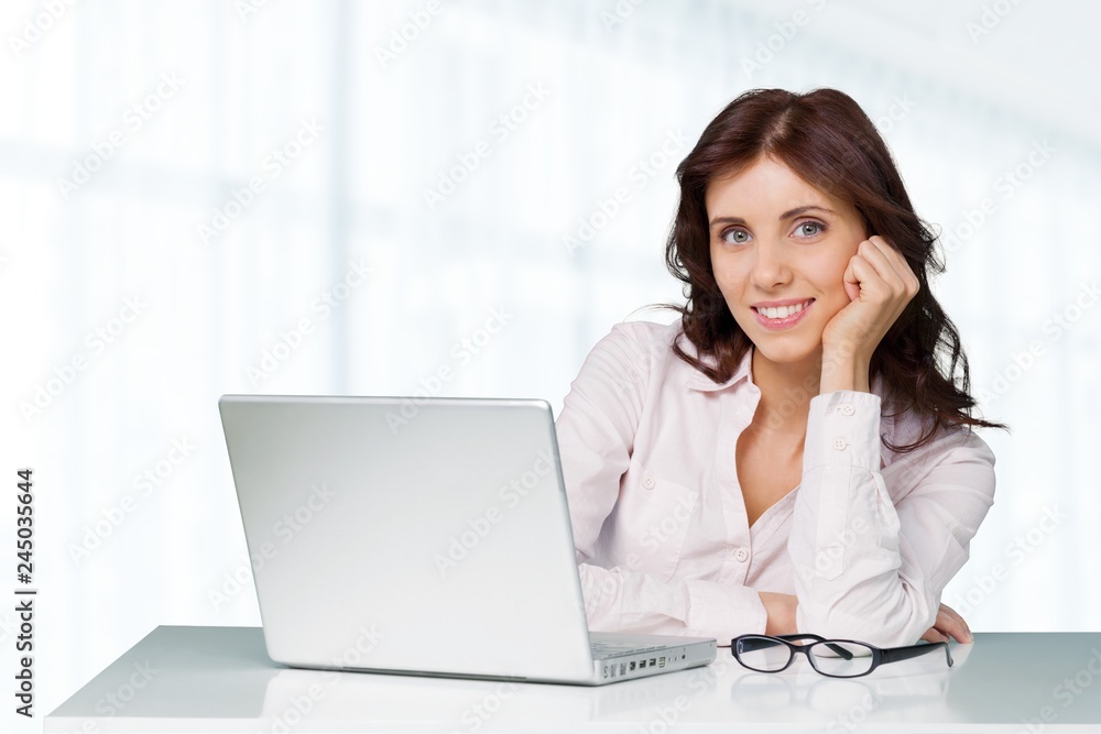 Attractive young woman speaking phone and using laptop Attractive young woman speaking phone and using laptop