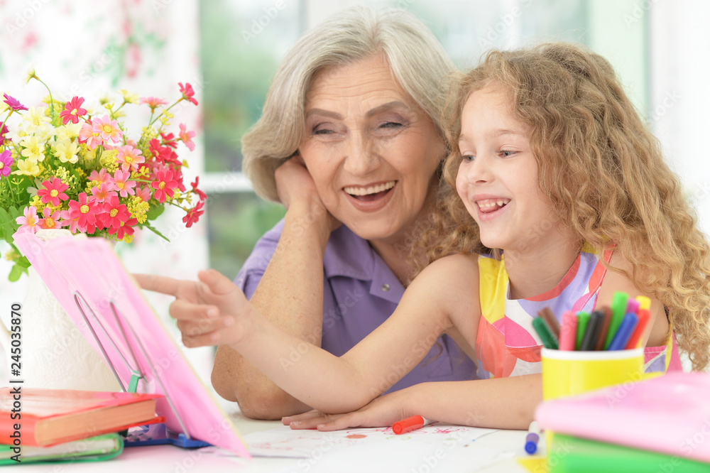 Portrait of schoolgirl studying with grandmother at home Portrait of schoolgirl studying with grandmother at home