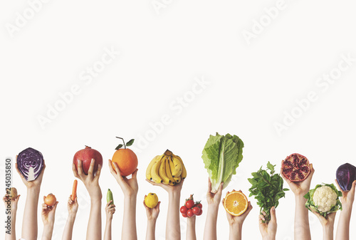 Hands holding different vegetables and fruit on isolated background