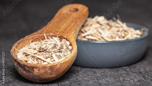 Dried root of siberian ginseng on dark background - medicine alternative