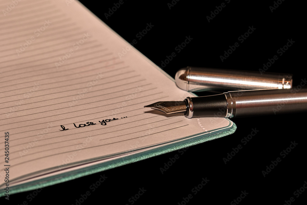 Fountain pen next to a notepad with the inscription Fountain pen next to a notepad with the inscription