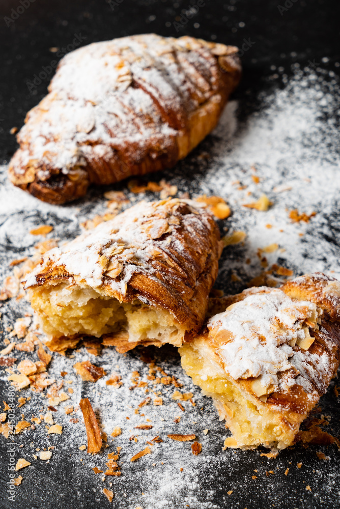 Fototapeta premium Croissants with almonds on the black background