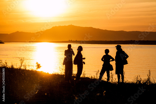 Silhouettes of people during a sunset at Irrawaddy (Ayeyarwady) river in Bagan, Myanmar
