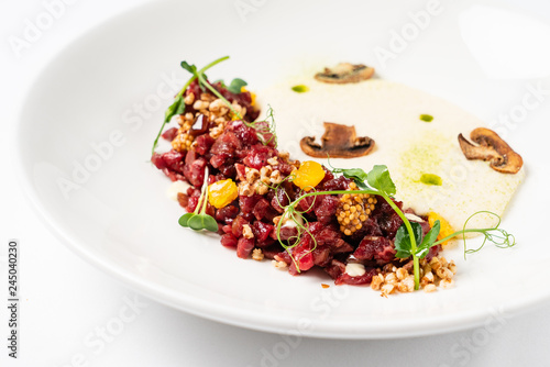 plate with delicious tartare and mushroom puree. Isolated on the white background